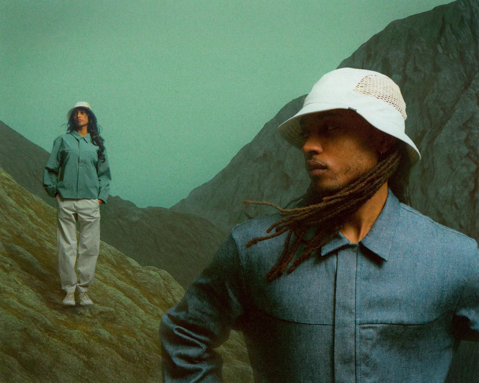 Man wearing Ciele Le jacket and hat posing on rocks, outdoor portrait