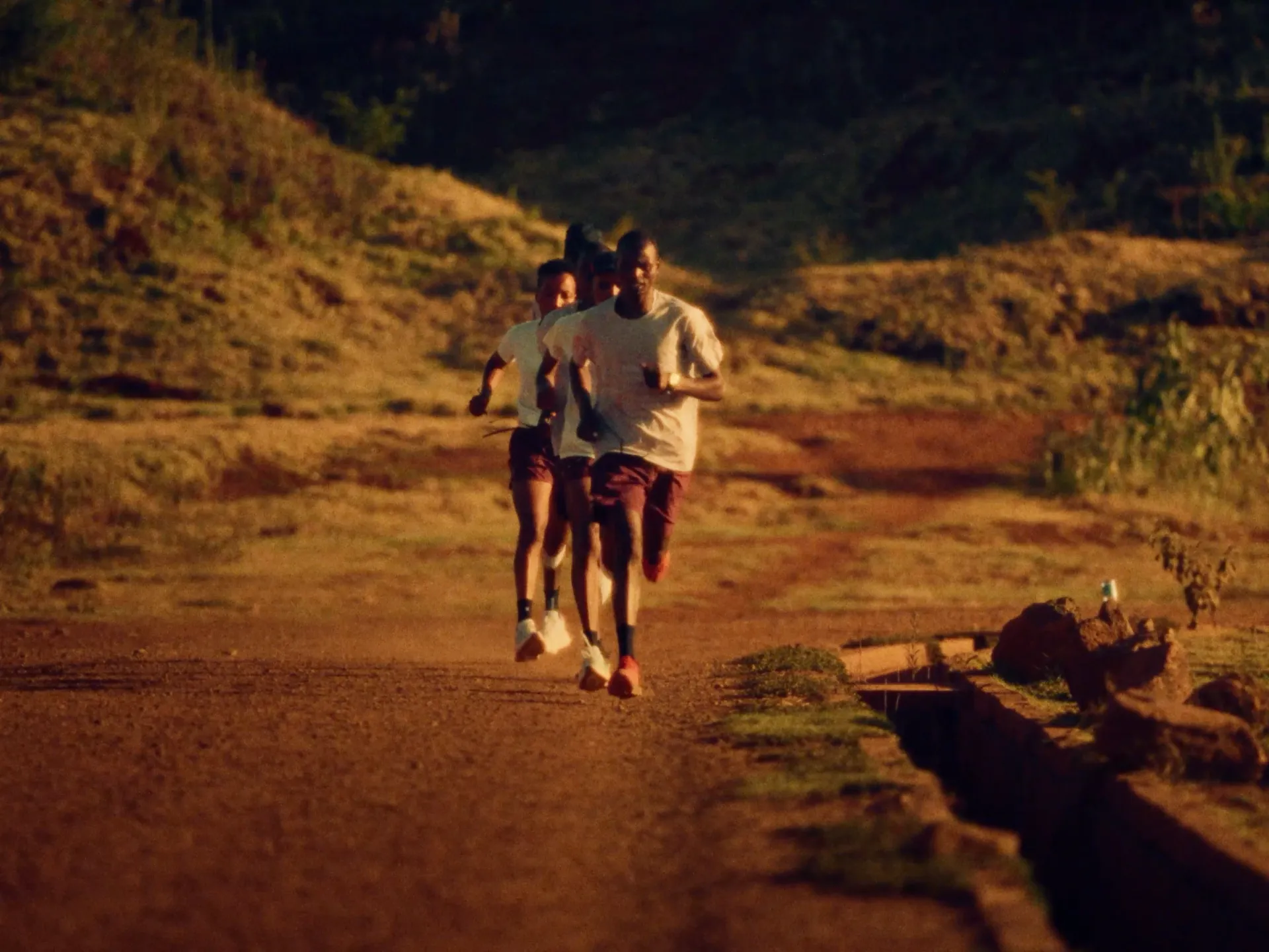Person running on a trail path wearing gloves and running shoes, Milimani project