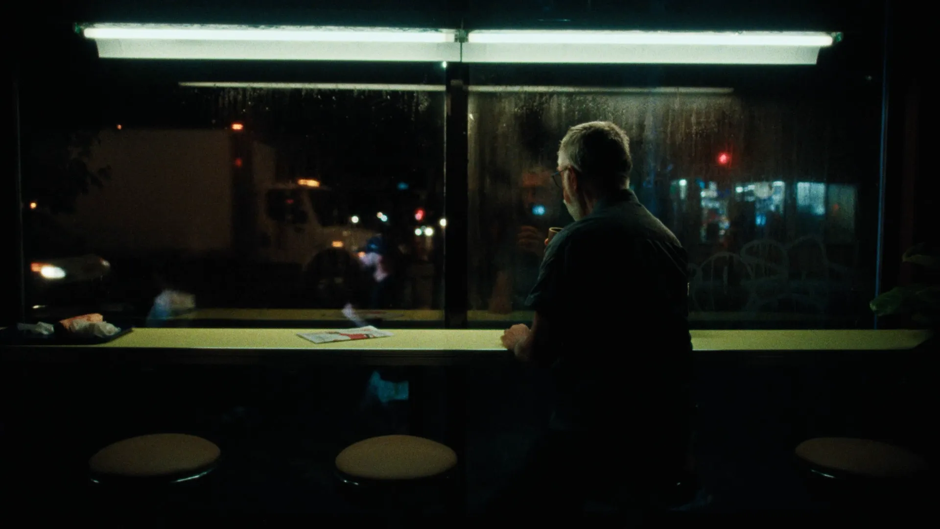 Man at a bar counter with ambient urban lighting, Summer Nights pub atmosphere