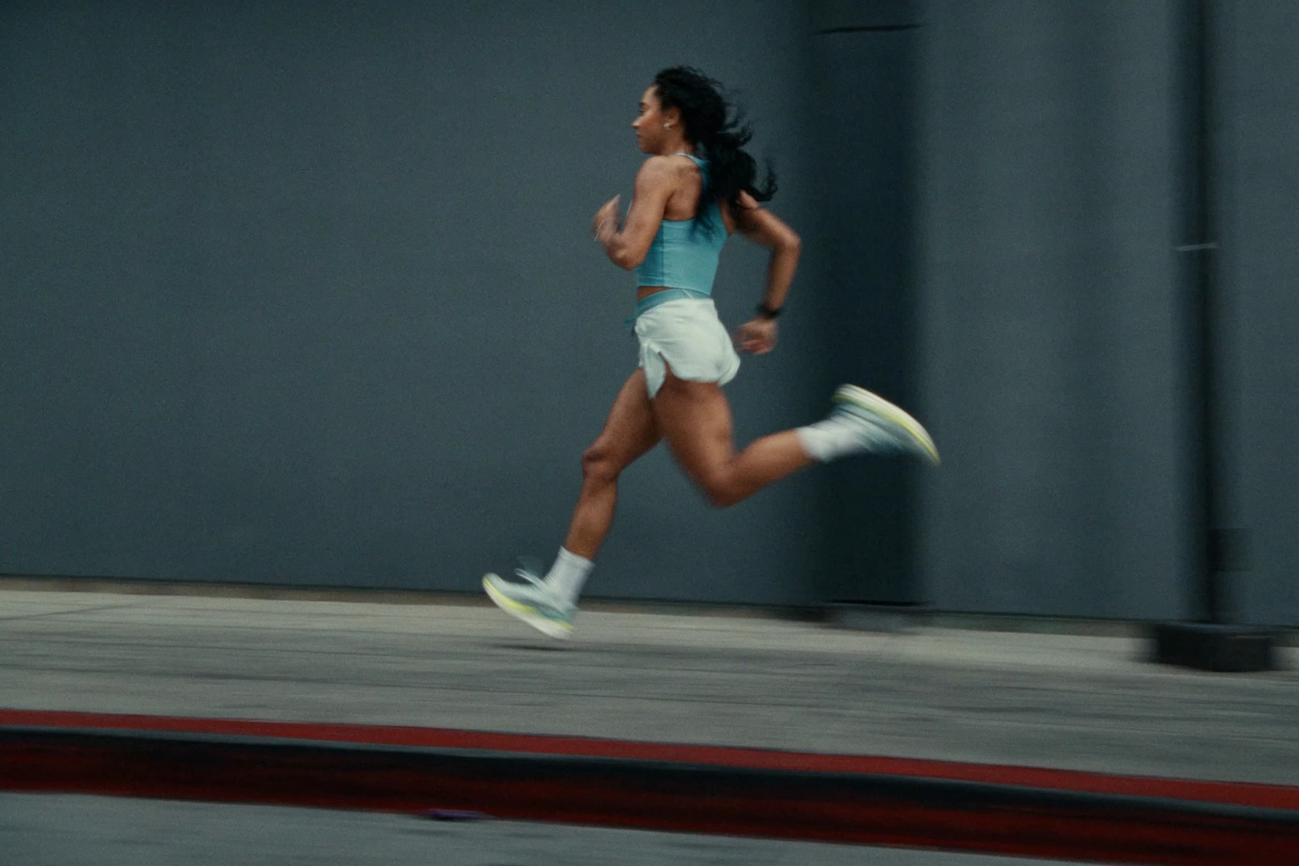 Woman running in Puma shorts and shoes, athletic performance photography
