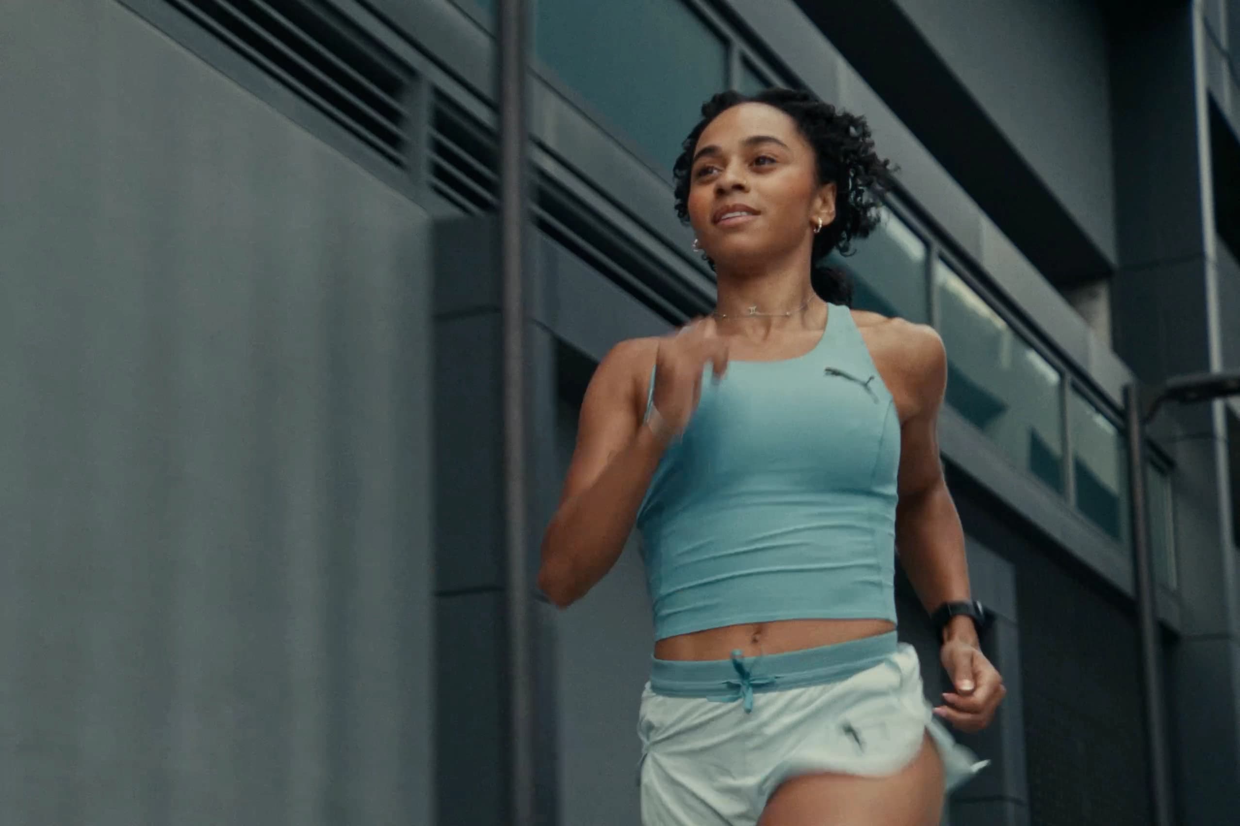 Woman in Puma vest with wristwatch, athletic portrait after workout
