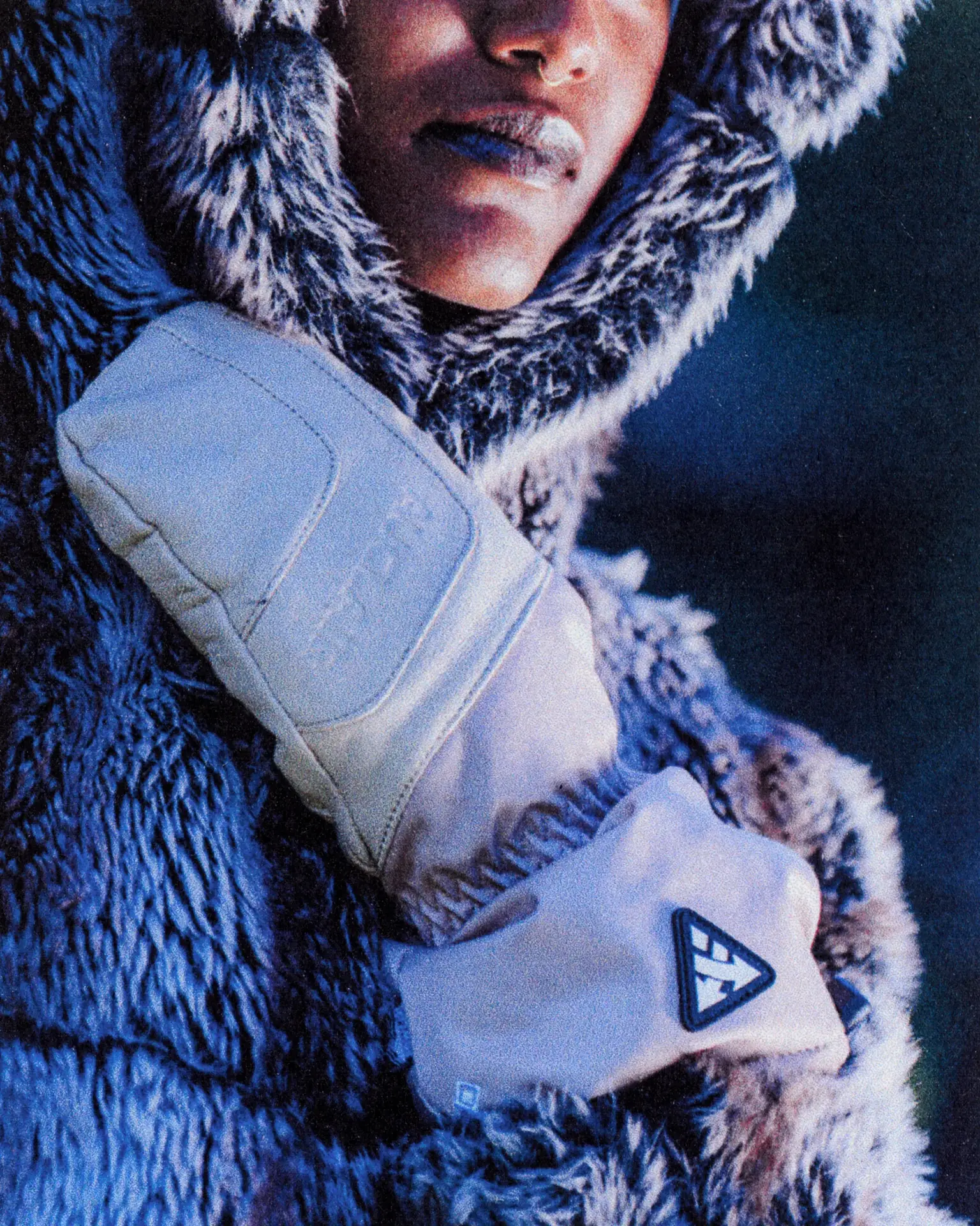 Person wearing Auclair gloves and coat holding a baby, winter family moment